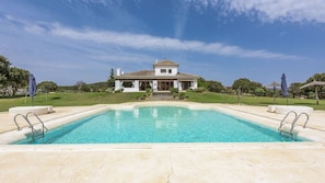 Uma piscina com uma casa ao fundo.