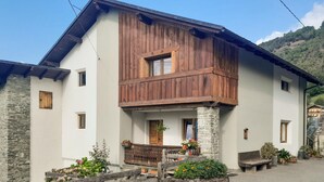 A two-story building with a stone foundation, wooden upper structure, and a balcony with wooden railings. - Cozy apartment in Verrayes with sauna (Verrayes)
