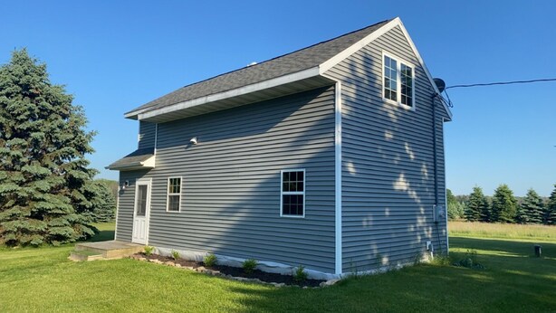 A two-story house with a gabled roof and a front porch. - 2 Bedrooms - Room to park boat! - Close to water & Potawatomi State Park (Sturgeon Bay)