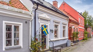 Uma fileira de edifícios em estilo tradicional europeu, com uma rua de paralelepípedos.