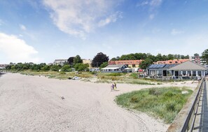 A beach with a sandy shore, a few people, and buildings in the background. - 4 bedroom beautiful home in Ystad (Ystad)