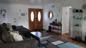 A living room with a sofa, coffee table, and a glass display cabinet.