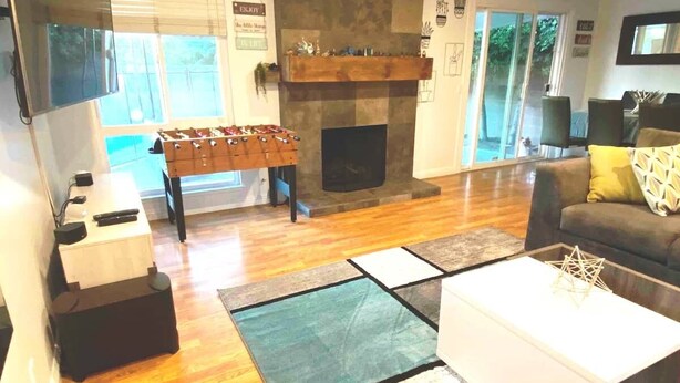 A living room with a foosball table, a fireplace, a sofa, and a coffee table.