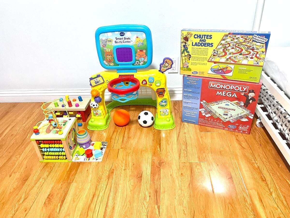 A children's play area with toys and games, including a Smart Shots Sports Center, Chutes and Ladders, and Monopoly Mega.