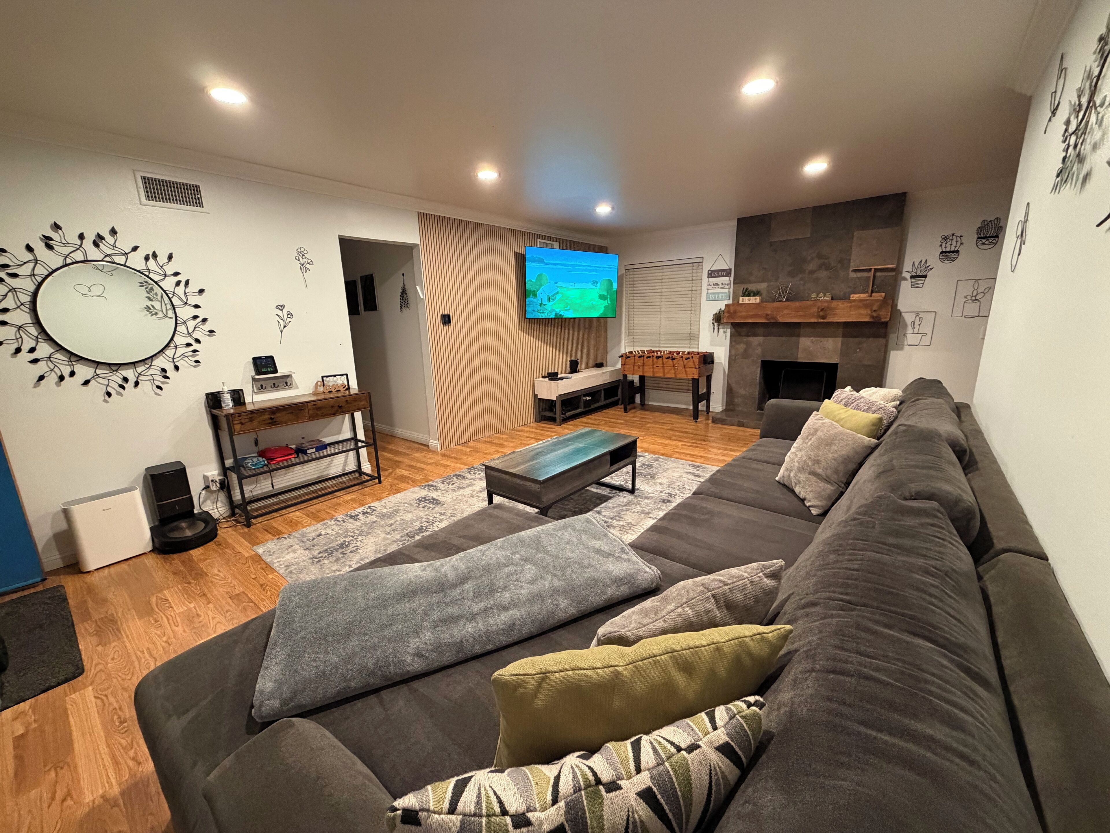 A modern living room with a grey sofa, a coffee table, a TV, and a fireplace.