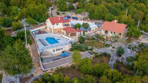 Une vaste propriété comprenant plusieurs bâtiments, une piscine et un paysage rocheux.