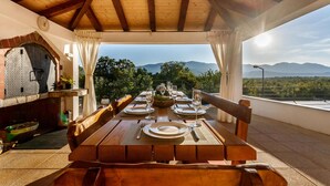 Une table en bois, dressée pour le repas, avec vue sur les montagnes.