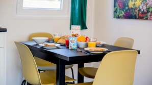 A breakfast table set with plates, bowls, glasses of orange juice, a carton of milk, and a slice of toast. - Gorgeous home in Breukelen with WiFi (Breukelen)