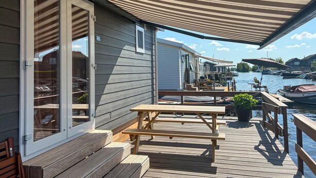 A wooden deck with picnic tables and benches, overlooking a marina with boats. - Gorgeous home in Breukelen with WiFi (Breukelen)