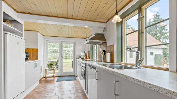 A modern kitchen with white cabinets, a stainless steel sink, and a wooden ceiling. - Beautiful home in Aakirkeby with WiFi (Aakirkeby)