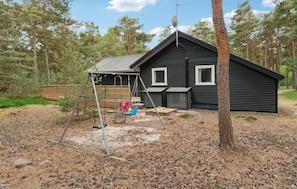 A cabin with a swing set and a satellite dish.