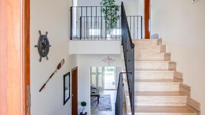 A wooden staircase with a black railing leading to a second-floor balcony. - Beach front home in Mallorca (Mallorca)