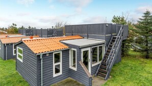 Un edificio moderno y modular con varias unidades, cada una con un pequeño porche y una escalera que conduce a una terraza plana.