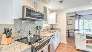 Una cocina moderna con encimeras de granito, electrodomésticos de acero inoxidable y un comedor con vistas.
