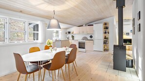 Eine moderne Küche mit weißen Schränken, einer zentralen Kochinsel und einem eingebauten Backofen.