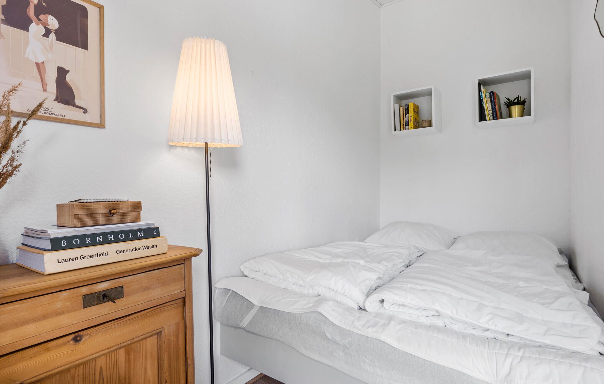 Una camera da letto con un letto, comodini, una lampada e scaffali.