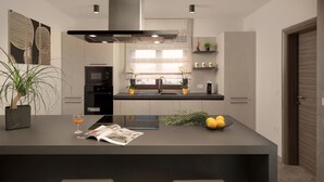 Una cocina moderna con una isla central, electrodomésticos integrados y un diseño minimalista.