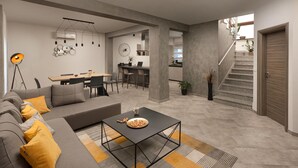 Una sala de estar moderna con un sofá, una mesa de centro y un comedor con sillas y una mesa.