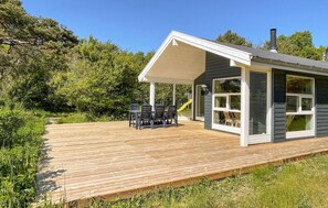 A small house with a wooden deck, a covered patio, and a large window. - 2 bedroom stunning home in Hasle (Hasle)