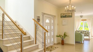 A staircase with wooden handrails leading to a door with a 'HOME' sign. - Beautiful villa with ocean & lagoon views,  walk to the beach! (Vau)