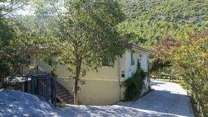A building with a staircase leading to a door, surrounded by trees and a cobblestone path. - Stunning apartment in Kucice (Kucice)