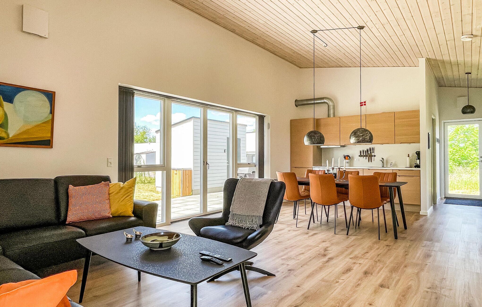 A spacious living area with a sofa, coffee table, and a dining table with chairs.