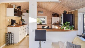 A modern kitchen with wooden accents, a dining area with a view, and a cozy seating area. - Lovely home in Huskvarna (Huskvarna)