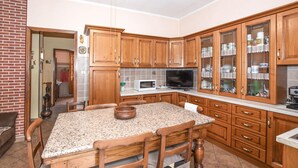 A kitchen with wooden cabinets, a granite countertop, and a dining table with chairs.