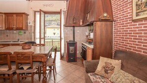 A cozy kitchen with wooden cabinets, a stove, and a dining area with a table and chairs.