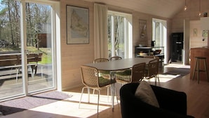 A dining area with a table and chairs, large windows, and a view of the outdoors. - 3 bedroom stunning home in Nexø (Nexø)