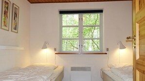 A room with two single beds, a window with a view of trees, and two wall-mounted lamps. - Stunning home in Nexø with WiFi (Nexø)