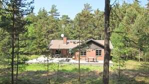 A cabin with a sloped roof, surrounded by dense forest. - Stunning home in Nexø with WiFi (Nexø)