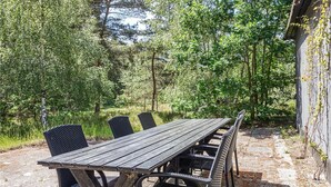Un tavolo da picnic in legno con sedie, in un giardino.