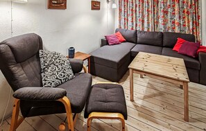 A living room with a sofa set, a wooden coffee table, a patterned throw, and a small side table. - Gorgeous home in Nexø with kitchen (Nexø)
