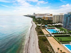 Ein Hotel an der Küste mit Blick auf den Strand, mehreren Schwimmbecken und einem großzügigen Gebäudekomplex.