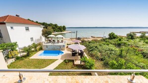 A residential property with a swimming pool, outdoor seating, and a view of the sea.