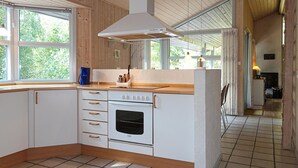 Une cuisine avec des armoires blanches, un four encastré et un plan de travail en bois.