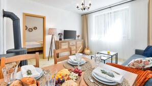 Ein modernes Wohnzimmer mit Essbereich, Fernseher und Kamin.