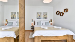Ein Hotelzimmer mit einem hölzernen Bett, weißer Bettwäsche und zwei Bildern von Hirschen an der Wand.