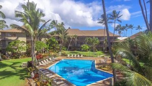 Ein Resort mit Swimmingpool, umgeben von Palmen und Liegestühlen.