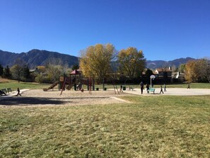 A park with playground equipment, benches, and a clear view of mountains in the background. - Mountain-View 5BR Retreat: Gym, Hot Tub, BBQ, Firepit, Playground, Sleeps 12 (Colorado Springs)