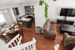 Un apartamento moderno con comedor, cocina, sala de estar y televisor.