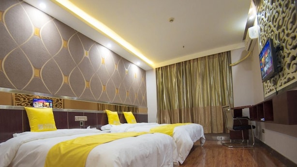 Habitación de hotel con dos camas, un televisor de pantalla plana y diseño moderno.