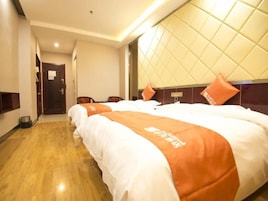 Una habitación de hotel con una cama grande, cabecera con diseño acolchado y suelo de madera.