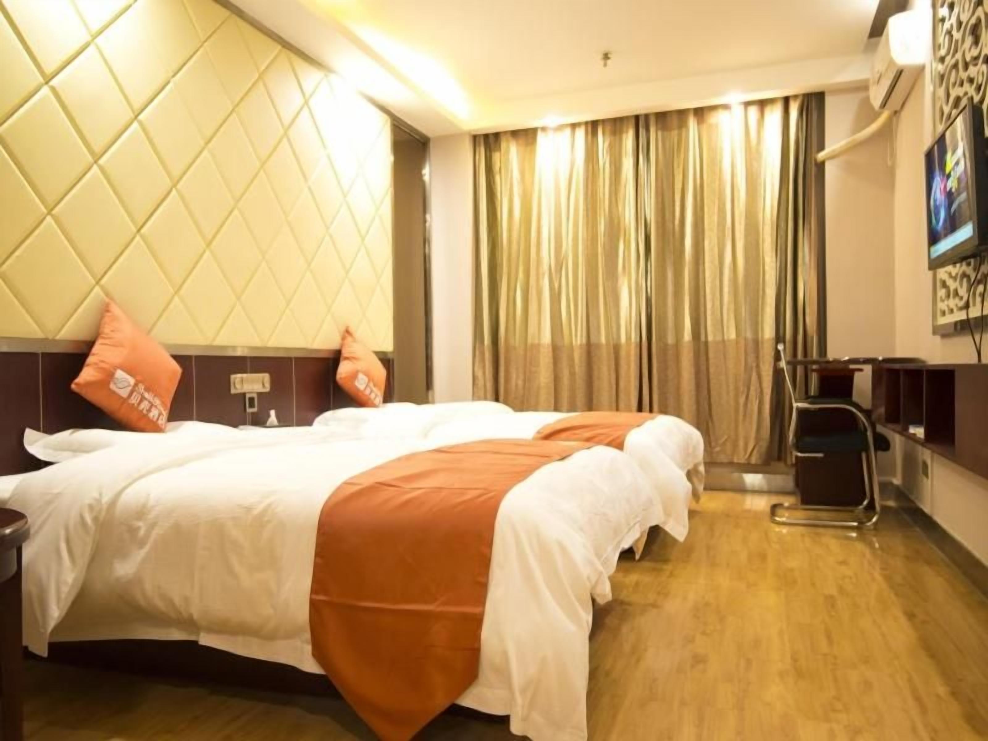 A hotel room with a bed, a desk, and a television.