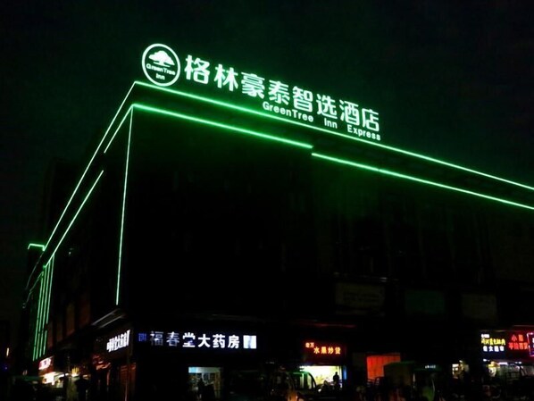 Une enseigne d’hôtel illuminée par des néons verts.