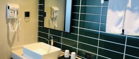 A modern bathroom with a white sink, a mirror, and a towel rack.