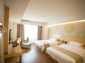 A hotel room with two beds, a desk with a chair, a small table with a plant, and a large window with curtains.