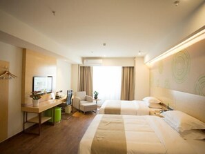 A hotel room with a bed, a desk, a chair, and a TV.