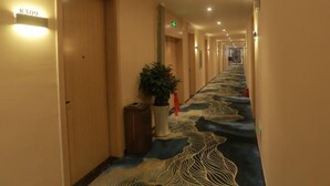 A hotel hallway with doors numbered 8309, a potted plant, and a patterned carpet. - Shell Hotel Chuzhou Economic Development Zone Internation Shangcheng (Chuzhou)
